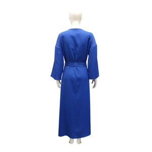 Dettaglio delle maniche lunghe con decorazioni di perle bianche su un abito blu navy