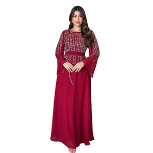 Dettaglio di paillettes argentate su abito lungo in chiffon bordeaux con maniche lunghe