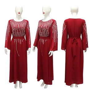 Dettaglio di un abito lungo in chiffon rosso scuro con motivi in strass scintillanti