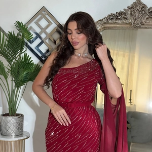 Détails d'une robe de soirée bordeaux à paillettes avec perles et cape en mousseline