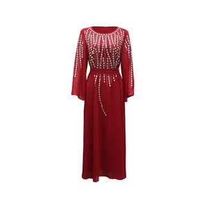 Dettaglio dell'abito in chiffon rosso con strass argentati e maniche lunghe da cerimonia