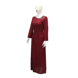 Close-up of intricate red floral lace and sparkling rhinestones on the dress neckline