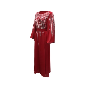 Dettaglio dell'abito in chiffon rosso con strass argentati e ampie maniche a campana