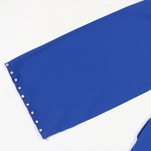 Dettaglio della manica di un abito blu reale con bordo in strass di cristallo cucito a mano