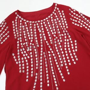 Dettaglio dell'abito in chiffon rosso con file verticali di strass rettangolari radianti
