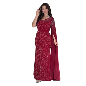 Détail de la robe de soirée bordeaux avec manche cape asymétrique et strass diagonaux
