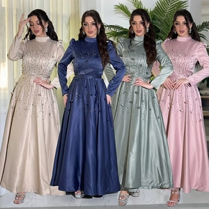 Close-up of elegant satin gowns with heavy beadwork sequins and chic puff sleeves