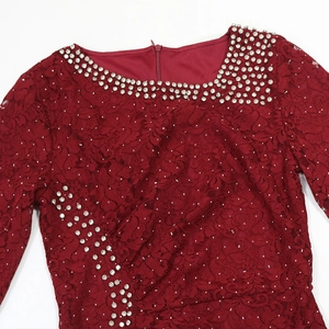 Detailed view of burgundy lace dress with silver rhinestones and sequin embellishments