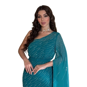 Détail d'une robe de soirée en mousseline bleu sarcelle avec strass et ceinture fine