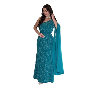 Détail d'une robe de soirée asymétrique bleu canard avec paillettes argentées et manche cape