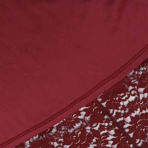 Detail of burgundy dress showing intricate floral lace stitching and premium fabric