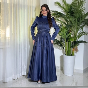 Close-up of heavy beadwork and floral embroidery on dark blue satin formal gown