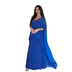 Détail de robe de soirée en mousseline bleu roi avec strass étincelants et cape à une épaule