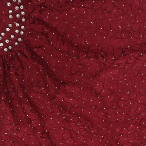 Close-up of burgundy lace fabric featuring intricate floral patterns and silver rhinestones