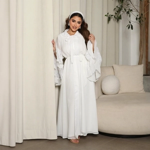 Detail of elegant lace patchwork sleeves and pleated layers on white robe dress