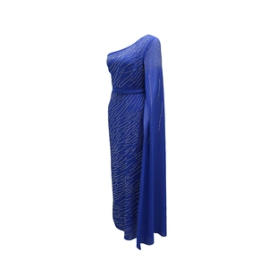 Détail d'une robe longue bleu roi à une épaule avec strass brillants et manche cape