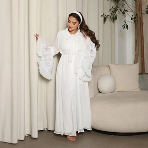 Detail of elegant white abaya dress featuring lace patchwork and pleated bell sleeves