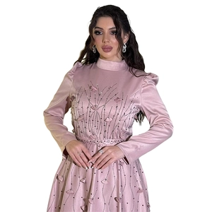 Detail of elegant pink satin dress featuring heavy beadwork and floral belt accents