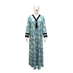 Detail view of blue V-neck printed kaftan dress with black fringe and lace trim