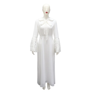 Detailed view of white long-sleeved dress featuring lace patchwork and pleated bell cuffs