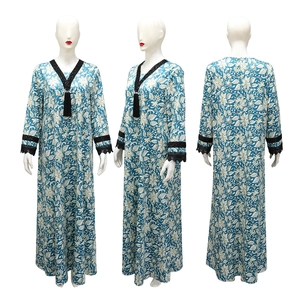 Detail of V-neckline with black tassel pendant and floral lace on a printed long dress