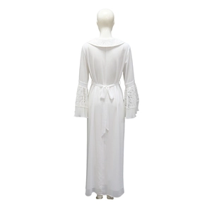 Detailed close-up of white chiffon maxi dress featuring elegant lace patchwork and pleated edges