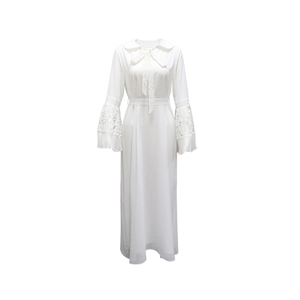 Close-up of white long-sleeve dress with lace patchwork on bell sleeves and Peter Pan collar