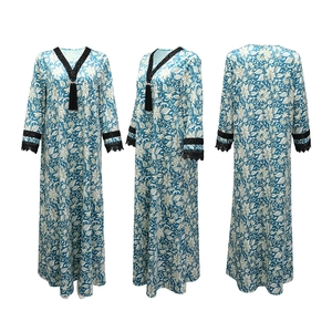 Close-up of V-neckline with black lace trim and tassel detail on floral kaftan dress