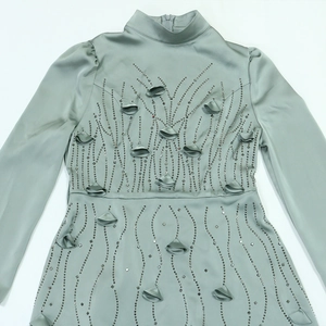 Detail of mint green satin gown with intricate beadwork and 3D floral accents