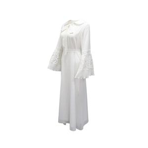 Detail of white maxi dress showing lace cuffs, pleated ruffles and bow neckline
