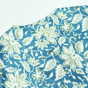 Detailed macro view of the elegant blue floral print fabric and fine stitching on V-neckline
