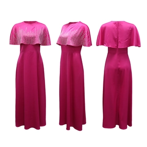 Dettaglio dell'abito lungo fucsia con decorazioni in strass e design a mantella