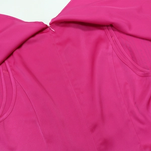 Dettaglio della cerniera invisibile sul retro della veste fucsia con tessuto liscio e fluido