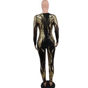 Detail of back zipper closure on long-sleeved sequined jumpsuit with gold feather patterns