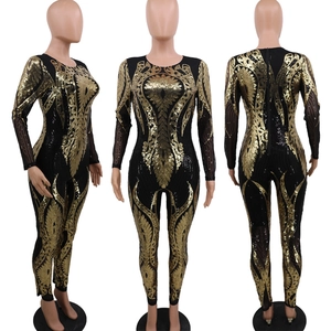 Detailed view of women's sequin jumpsuit with golden feather patterns on black mesh