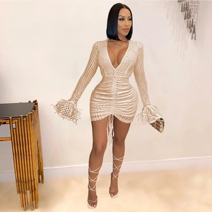 Detailed view of champagne gold sequined dress featuring feather cuffs and drawstring waist