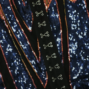Detail of dark sequin fabric with wave patterns and silver metal hook-and-eye closures