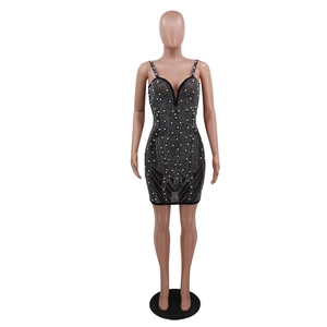 Détail d'une mini-robe sexy à col en V profond avec perles blanches et ornements strass