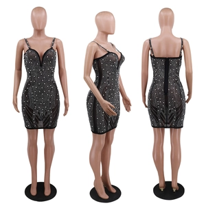 Détails d'une mini robe moulante noire avec perles et décolleté plongeant en V