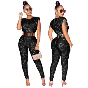 Detail of a sequined sleeveless jumpsuit in black with a polished gold metal belt