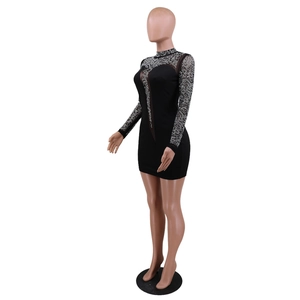 Detail of sheer mesh patchwork and glittering rhinestones on a slim black mini dress