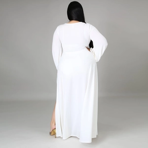 Detail view of white long-sleeve dress with high side slit and elegant flowing skirt