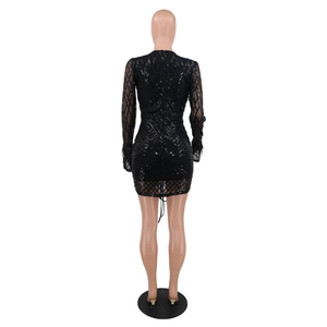 Detail of black sequined evening dress featuring feather trim cuffs and zipper back