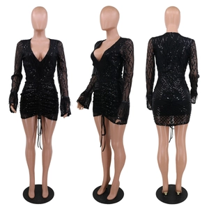 Detail of black sequin dress featuring sheer mesh sleeves with feather trim and ruched design