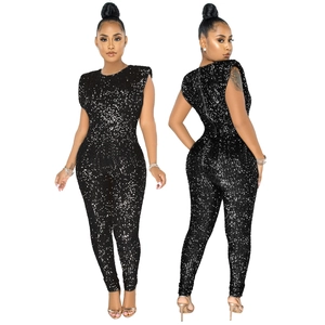 Detail of black sequined tight jumpsuit featuring padded shoulders and back metal zipper