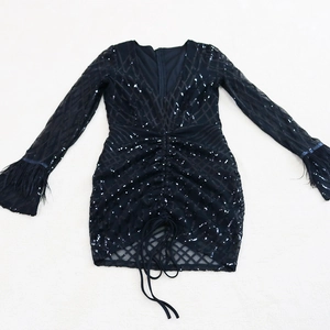 Detail of black sequin mini dress with deep V-neck and ruched drawstring hem