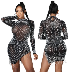 Détails d'une robe en résille avec strass, perles, franges et découpe dans le dos