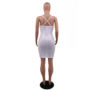 Detail of cross back straps and iridescent sequins on a slim fit white tassel dress