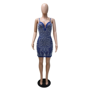 Détail de robe moulante bleu roi avec motifs de perles blanches et tissu en maille