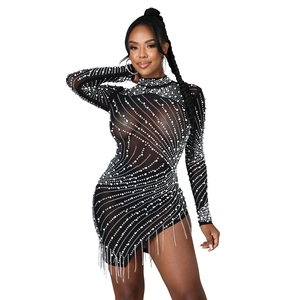 Détail d'une robe en résille noire transparente avec strass brillants et perles